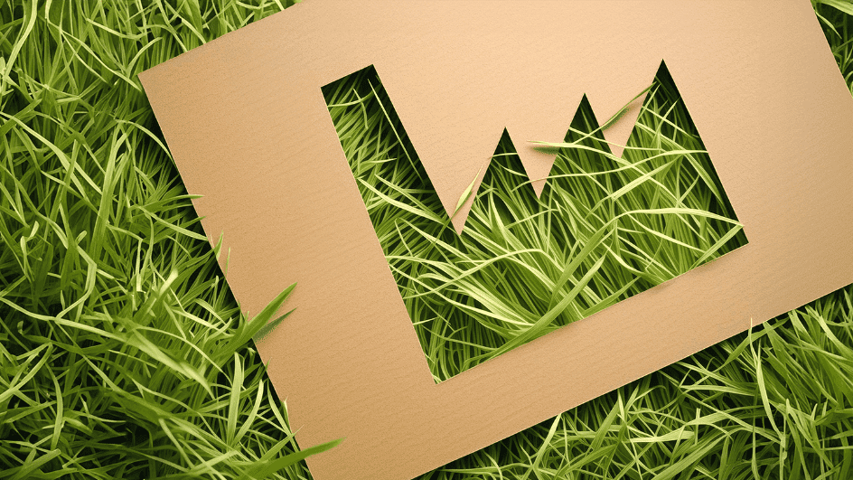 Immagine di una sagoma di un’industria ritagliata su un cartoncino appoggiato sull'erba.